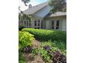 Backyard showcasing lush garden beds with a variety of plants and shrubs, alongside a home's exterior with doors and windows at 9229 Tamarack Dr, Indianapolis, IN 46260
