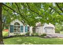 Lovely white brick home showcasing beautiful landscaping, arched window, and charming curb appeal at 10444 Indian Lake N Blvd, Indianapolis, IN 46236