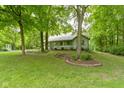 Quaint one-story home nestled among mature trees, featuring a covered front porch and established landscaping at 10808 Greenbriar Dr, Fishers, IN 46037