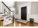 Welcoming foyer with hardwood floors, staircase and black door to create a lasting first impression at 11875 Durbin Dr, Carmel, IN 46032