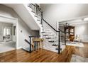 Elegant staircase featuring wood steps, black banister, and white risers complements the hardwood floors at 11875 Durbin Dr, Carmel, IN 46032