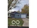 Charming single-story home featuring blue siding, a covered front porch, attached garage and a well-maintained lawn at 1321 Lennox St, Anderson, IN 46012