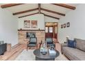 Living room with vaulted ceilings, wood beams, a brick fireplace, and comfortable seating arrangement at 138 Plaza Chica St, Greenwood, IN 46143