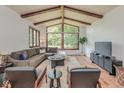 Bright living room features vaulted ceilings, wood beams, hardwood floors, and a large window with a beautiful view at 138 Plaza Chica St, Greenwood, IN 46143