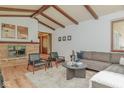 Cozy living room features a brick fireplace, hardwood floors, wood beams, and comfortable seating at 138 Plaza Chica St, Greenwood, IN 46143
