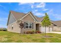 Charming single-story home with a well-manicured lawn, three-car garage and beautiful blue and brown accents at 1758 Pelham Dr, Greenwood, IN 46143