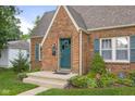 Charming brick home features a teal door, complemented by landscaping and inviting curb appeal at 1944 Union St, Columbus, IN 47201