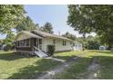 Quaint home featuring a screened-in porch, cream siding and a detached garage at 2245 N Ritter Ave, Indianapolis, IN 46218