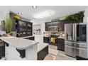 Modern kitchen with stainless steel appliances, stylish dark cabinets, and quartz countertops at 2717 Reflection Way, Greenwood, IN 46143