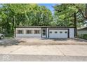 Exterior of home with vinyl siding and garage door nestled amongst mature trees and concrete driveway at 3529 Hunt St, Plainfield, IN 46168