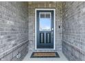 The exterior of the front door, features a welcoming welcome mat and brick surround at 3839 Albert Ln, Bargersville, IN 46106