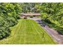Inviting single-story home featuring an expansive green lawn, mature trees, and a private driveway at 450 W 93Rd St, Indianapolis, IN 46260