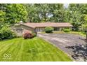 Charming home boasting a well-maintained lawn, circular driveway, and mature landscaping for added privacy at 450 W 93Rd St, Indianapolis, IN 46260