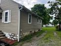 Exterior side view showing siding, white trim and a small grass and gravel area at 4715 Normal Ave, Indianapolis, IN 46226