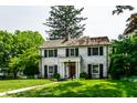 Beautiful two-story home featuring a well-manicured lawn, lovely landscaping, and black window shutters at 5261 N Pennsylvania St, Indianapolis, IN 46220