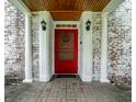 Inviting front entrance features brickwork, columns, black lighting fixtures and a vibrant red door at 5261 N Pennsylvania St, Indianapolis, IN 46220