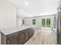 Stylish kitchen island with shaker cabinets, quartz counters, stainless appliances, and slider to back yard at 5289 Pine Hill Dr, Noblesville, IN 46062