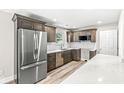 Modern kitchen with stainless steel appliances, shaker cabinets, quartz counters, and wood-look flooring at 5289 Pine Hill Dr, Noblesville, IN 46062