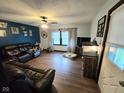 Comfortable living room with a large leather sofa, ceiling fan, and bright natural light at 627 Plum St, Noblesville, IN 46060