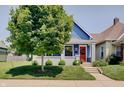 Charming blue home with a red door, green lawn, and inviting curb appeal at 712 Orange St, Indianapolis, IN 46203