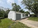 Home with well-kept yard and a gray garage door and window accents, giving it a clean and modern look at 7641 E 35Th St, Indianapolis, IN 46226