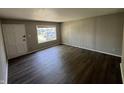 Inviting living room with sleek, dark flooring, freshly painted walls, a bright window, and a classic white door at 7641 E 35Th St, Indianapolis, IN 46226
