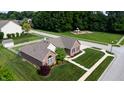 Aerial view of a brick home showcasing its manicured lawn, mature trees, and nearby playground at 8028 Meadow Bend Ln, Indianapolis, IN 46259