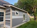 Exterior shot of a light-colored house with light trim and new windows at 827 W 9Th St, Anderson, IN 46016