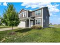 A beautiful two-story home with gray siding, white trim, a lush green lawn, and mature landscaping at 851 Sonoma Ln, Greenfield, IN 46140
