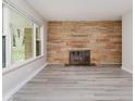 Inviting living room showcasing a stone fireplace and large window overlooking the green outdoors at 91 N Raceway Rd, Indianapolis, IN 46234
