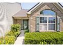 Inviting front entrance with well-maintained landscaping and a combination of brick and siding exterior at 10668 Whippoorwill Ln, Indianapolis, IN 46231