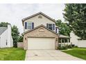 Attractive two-story home with a two-car garage, blue shutters, and a well-maintained lawn at 1112 Halifax Ct, Indianapolis, IN 46231
