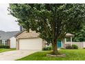 Beautifully landscaped yard with large tree accenting the exterior of this two-story home at 1112 Halifax Ct, Indianapolis, IN 46231