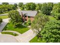 A beautiful brick home with mature trees, green lawn, and a long driveway at 11354 Royal Pl, Carmel, IN 46032