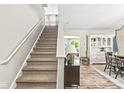 Inviting entryway with a staircase, modern console table, and a glimpse into the living and dining areas at 12259 Sweet Creek Trl, Fishers, IN 46037