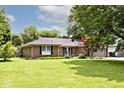 A charming brick home with green lawn, mature trees, and an inviting landscape at 1345 Westwind Dr, Avon, IN 46123