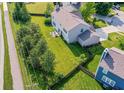 Aerial view showcases a spacious backyard with green lawn, mature trees, and a fence line defining the property at 14109 Secretariat Ct, Carmel, IN 46074