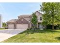 Charming two-story home with a well-manicured lawn, attached three-car garage, and inviting curb appeal at 14109 Secretariat Ct, Carmel, IN 46074