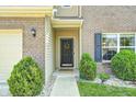 A welcoming front entrance with a decorated door, stone walkway and manicured bushes at 15178 Silver Charm Dr, Noblesville, IN 46060