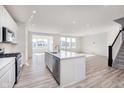 Modern, open-concept kitchen featuring a center island, stainless steel appliances, and wood flooring at 18955 Seaforth Way, Westfield, IN 46074