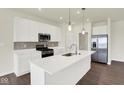 Stylish kitchen featuring a large island with quartz countertops, stainless steel appliances, and modern pendant lighting at 2021 Frost Line Ln, Greenfield, IN 93927
