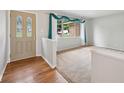 Inviting foyer with hardwood floors transitioning to carpeted living area and decorative leaded glass door at 230 Love Ave, Greenwood, IN 46142
