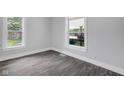 Bright bedroom with gray floors, white trim, and natural light streaming through two large windows at 26098 Six Points Rd, Sheridan, IN 46069