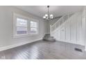 Bright living room features hardwood floors, natural light, staircase, and a modern chandelier at 2860 Winthrop Ave, Indianapolis, IN 46205