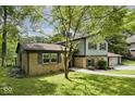 Two-story home with brick accents and a three-car garage surrounded by lush greenery at 3545 Whippoorwill Lake N Dr, Monrovia, IN 46157