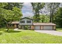 Two-story home with brick accents and a three-car garage surrounded by lush greenery at 3545 Whippoorwill Lake N Dr, Monrovia, IN 46157