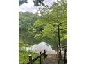 Scenic view of a calm lake with a private wooden dock, surrounded by lush greenery and trees at 3545 Whippoorwill Lake N Dr, Monrovia, IN 46157