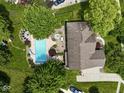 Aerial view of backyard oasis featuring a pool, patio, firepit, and well-maintained landscaping at 4084 Mountbatton Dr, Greenwood, IN 46143