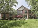 Charming brick home with a manicured lawn, mature trees, and attractive landscaping at 4084 Mountbatton Dr, Greenwood, IN 46143