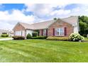 Well-maintained home featuring manicured landscaping, a pristine lawn, and tasteful brick accents at 413 Blue Spring Dr, Indianapolis, IN 46239